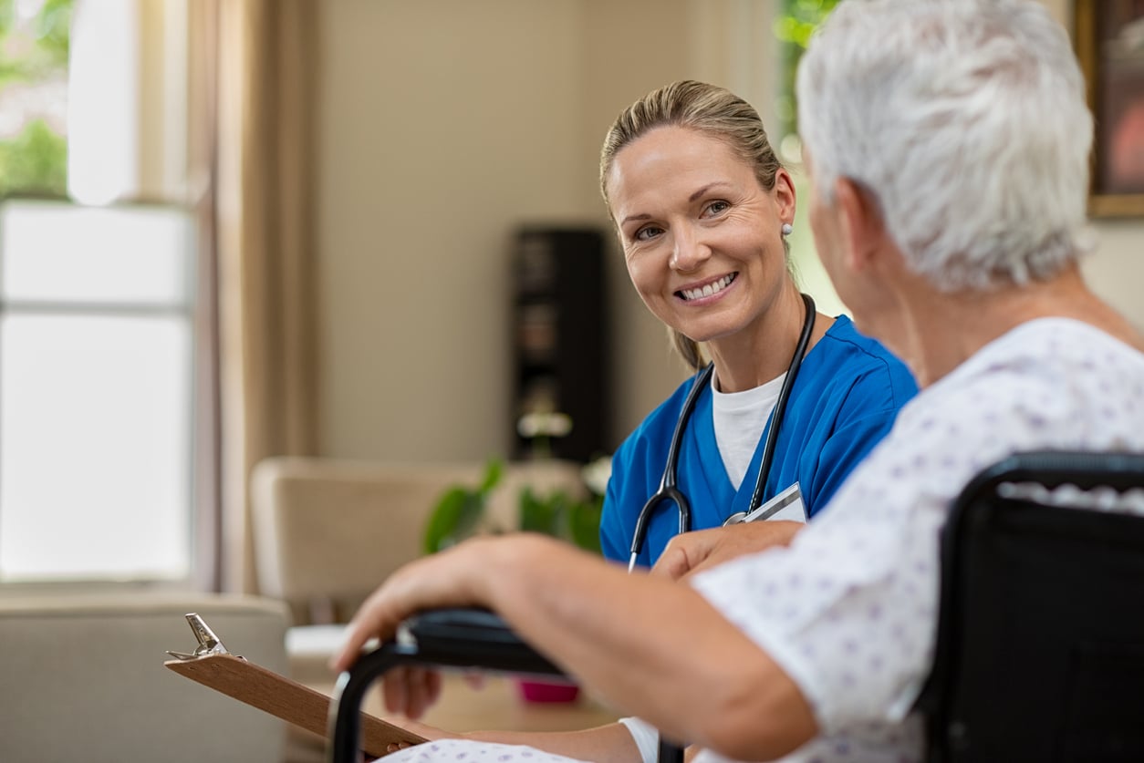 Friendly nurse talking to senior patient about bowel care