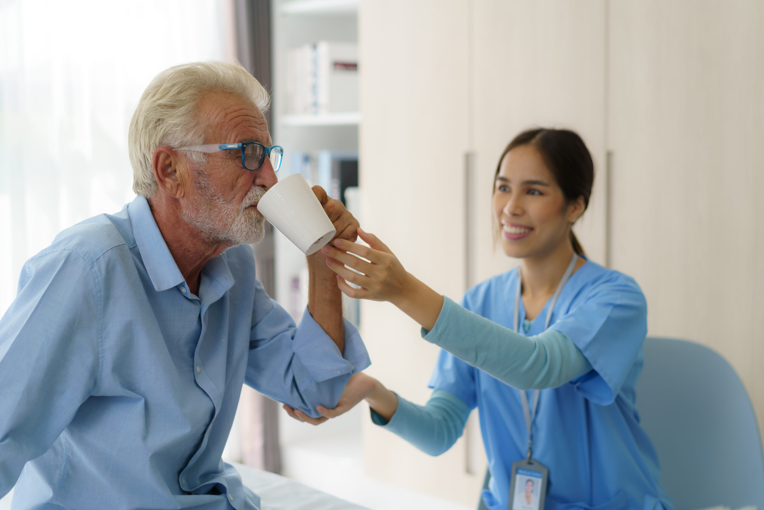 A caregiver assists an elderly person with Parkinson's Disease in managing their GI tract symptoms.